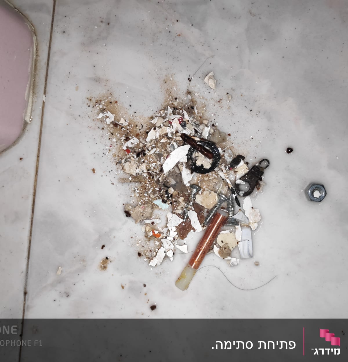 ברגים, אומים וחלקי צנרת על רצפה מלוכלכת